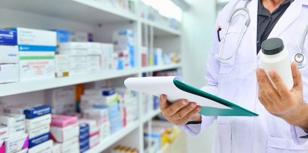 pharmacist-holding-medicine-bottle-computer-tablet